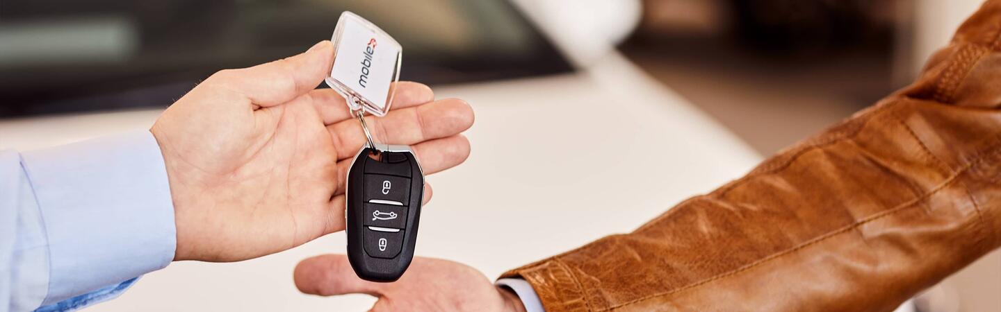 Car salesmen with car key in hand